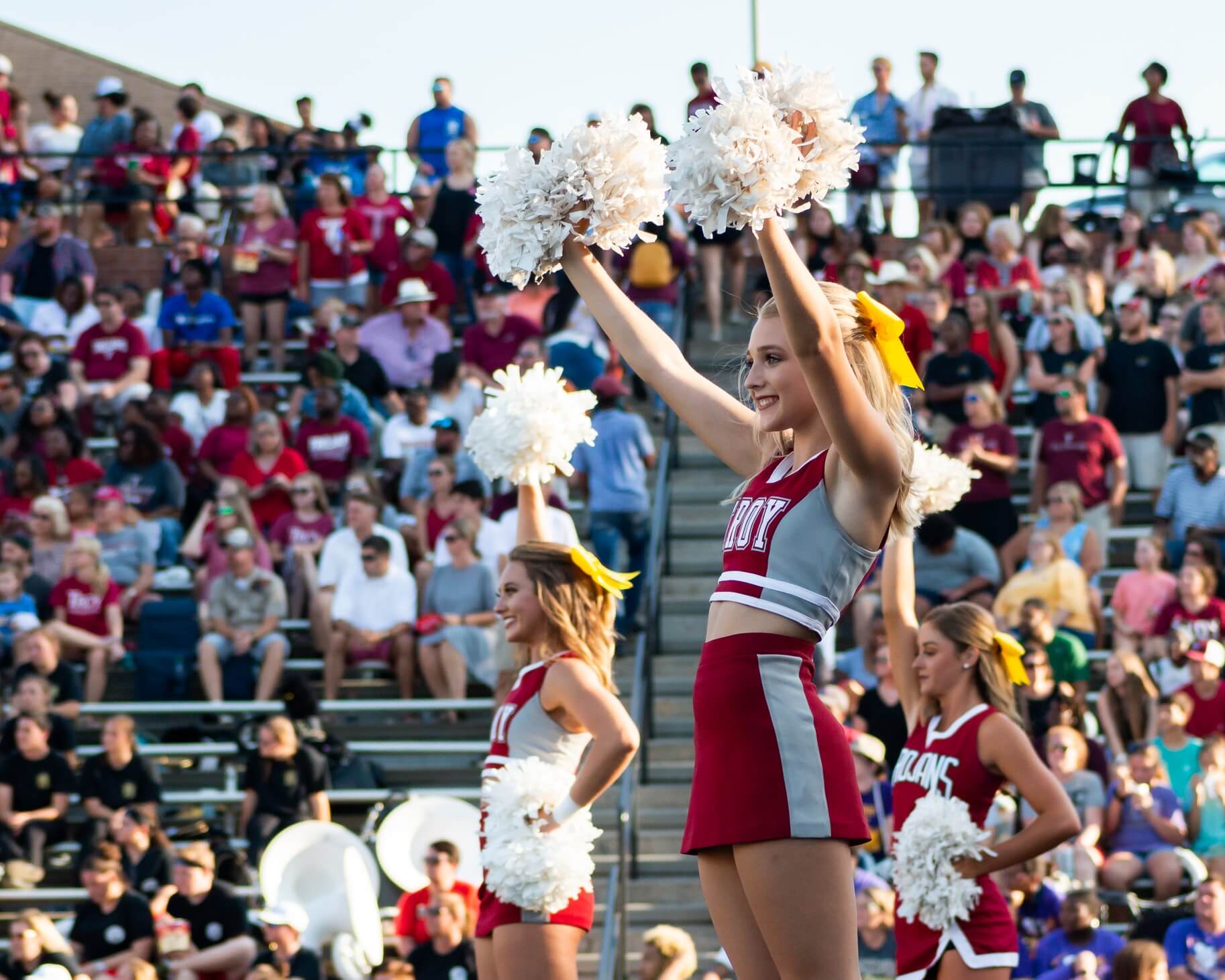 Cheerleaders wave pom-poms at a sports game