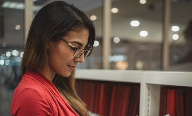 Transfer student reads a book in a library