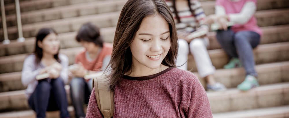 Student smiles as she looks at scholarships for Chinese students